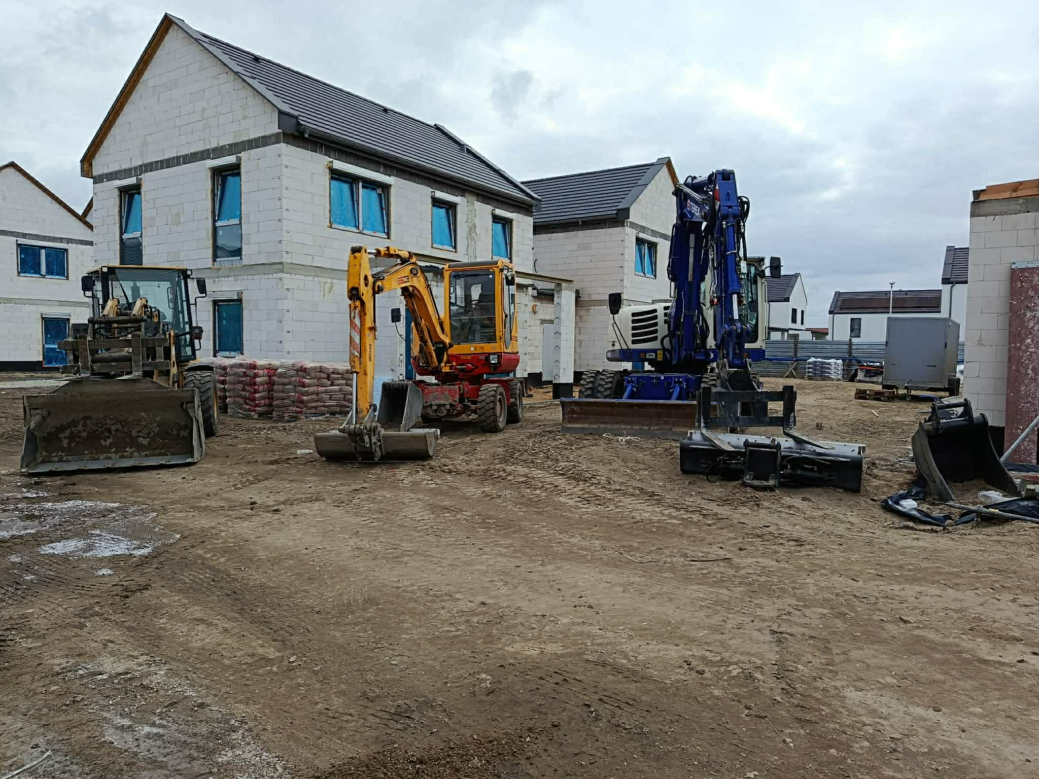 Trzy maszyny budowlane na placu – koparka mini, Terex i ładowarka, gmina Długołęka