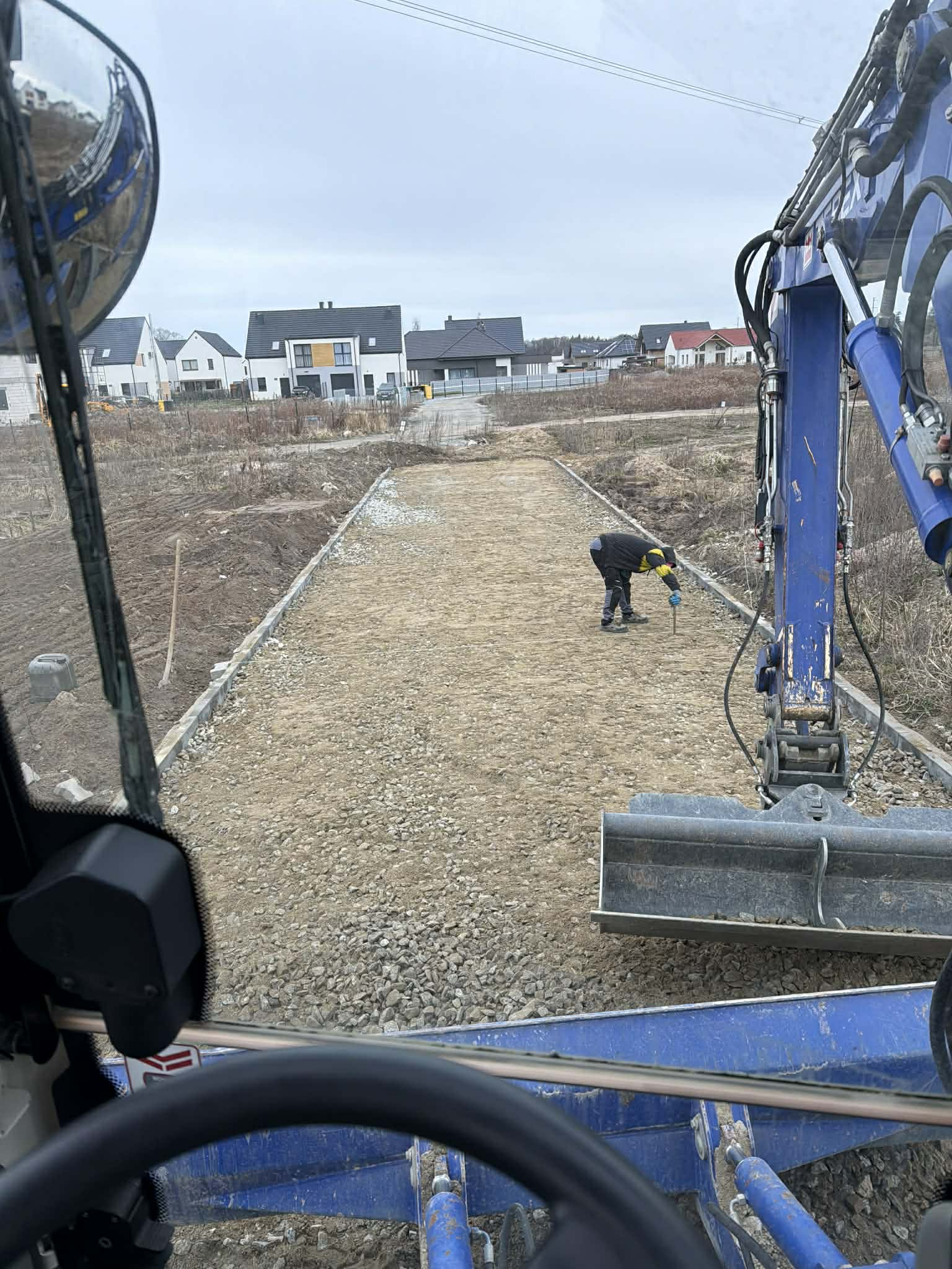 Widok z kabiny koparki – przygotowanie podłoża pod nawierzchnię brukowaną, Długołęka