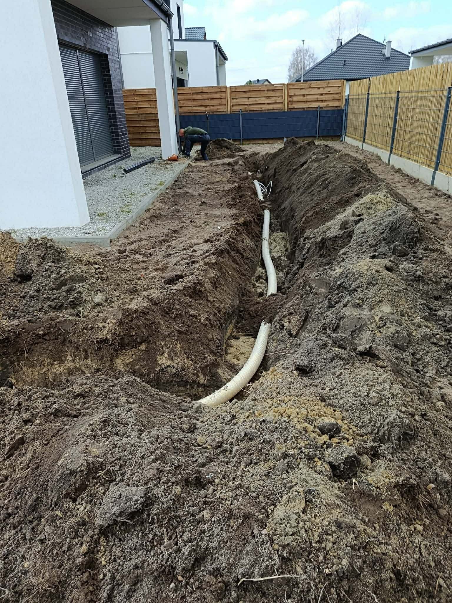 Wykop rowu z instalacją kanalizacyjną – prace ziemne przy domu, Długołęka